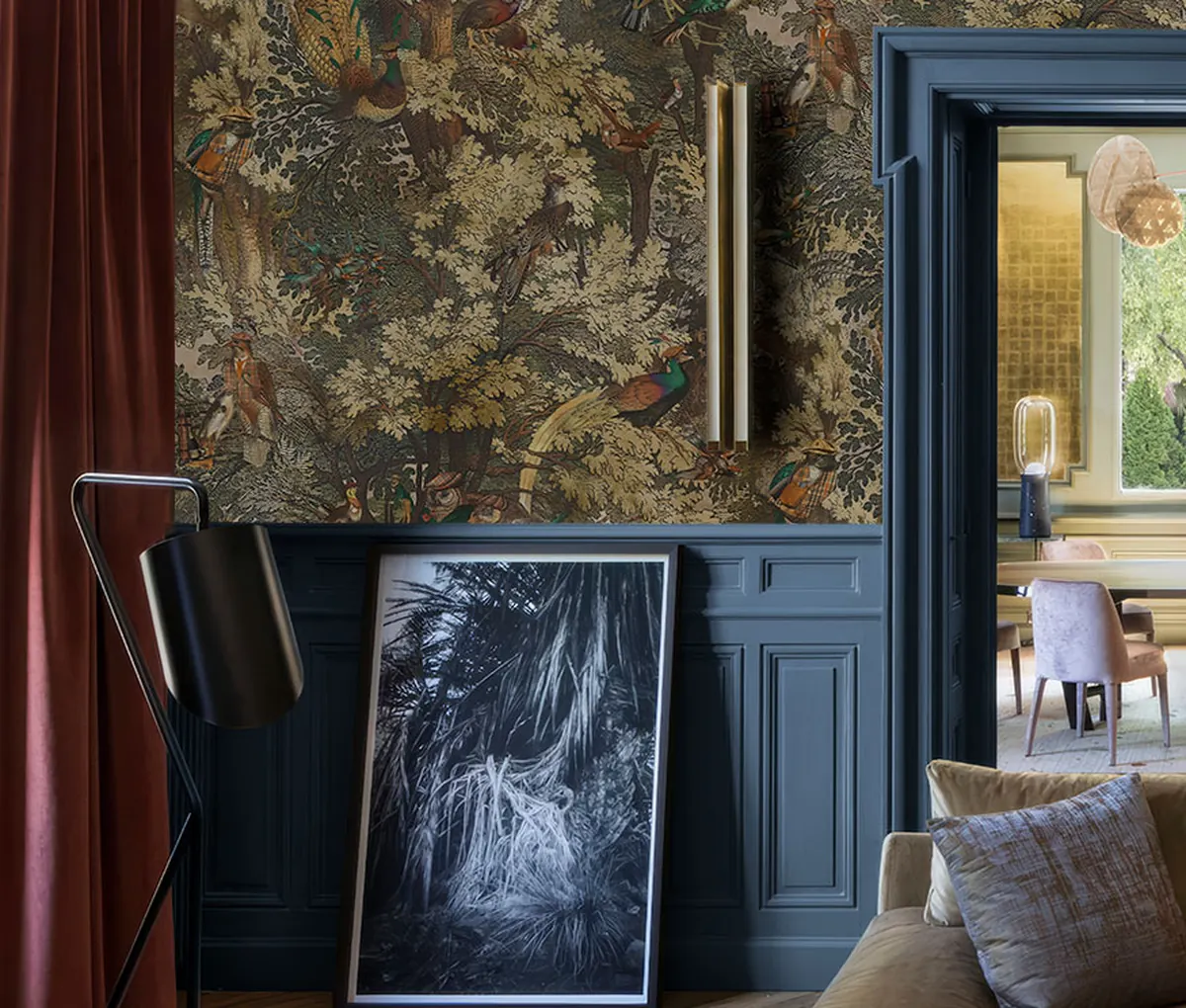 Bird and woodland wallpaper in a furnished room with blue paneling and a doorway